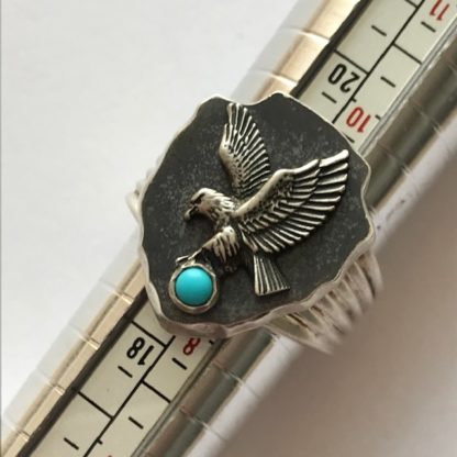 Bague en argent massif 925 style Améridienne avec un aigle attrapant une Turquoise, la plaque est rivé à la bague et est de très bonne manufacture.