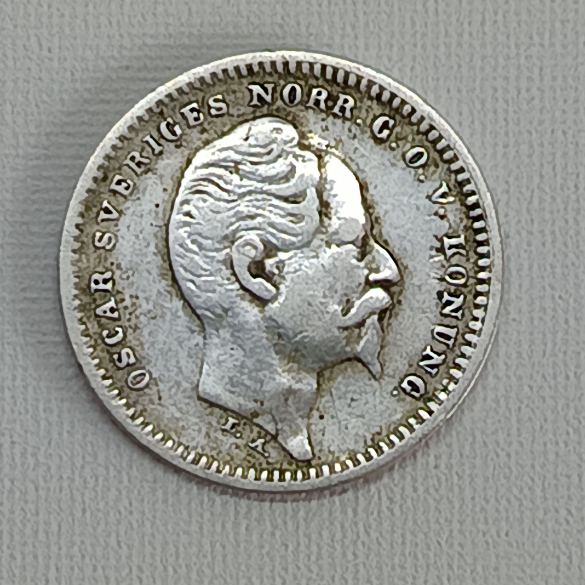 Bien sûr. Voici les informations sur la pièce de 25 öre de 1856, traduites en français. La pièce de 25 öre de 1856 a été frappée sous le règne du roi Oscar Ier de Suède. Il s'agit d'une pièce en argent dont les principales caractéristiques sont les suivantes : * Souverain : Oscar Ier de Suède (règne : 1844-1859) * Atelier monétaire : Stockholm (marqué par "ST") * Tirage : Environ 1 763 000 exemplaires * Composition : 75 % d'argent * Poids : 2,13 grammes * Diamètre : 17,7 mm Description de la pièce * Avers (face) : On y voit le portrait d'Oscar Ier tourné vers la droite, avec la légende "OSCAR SVERIGES NORR. G.O.V. KONUNG" (Oscar Roi de Suède, de Norvège, des Goths et des Wendes). Les initiales de la graveuse, "L.A." (Lea Ahlborn), se trouvent en dessous du cou. * Revers (pile) : Le revers affiche la valeur faciale "25 ORE" et la date "1856" à l'intérieur d'une couronne de lauriers, surmontée d'une couronne royale. Les initiales du maître de la monnaie, "S.T." (Sebastian Tham), y sont également présentes. Valeur de la pièce La valeur de cette pièce dépend beaucoup de son état de conservation. * En bon état (très circulé) : La valeur peut varier entre 5 et 30 euros. * En excellent état (non circulé) : Une pièce en parfait état peut valoir plus de 60 euros. Ces chiffres sont des estimations.