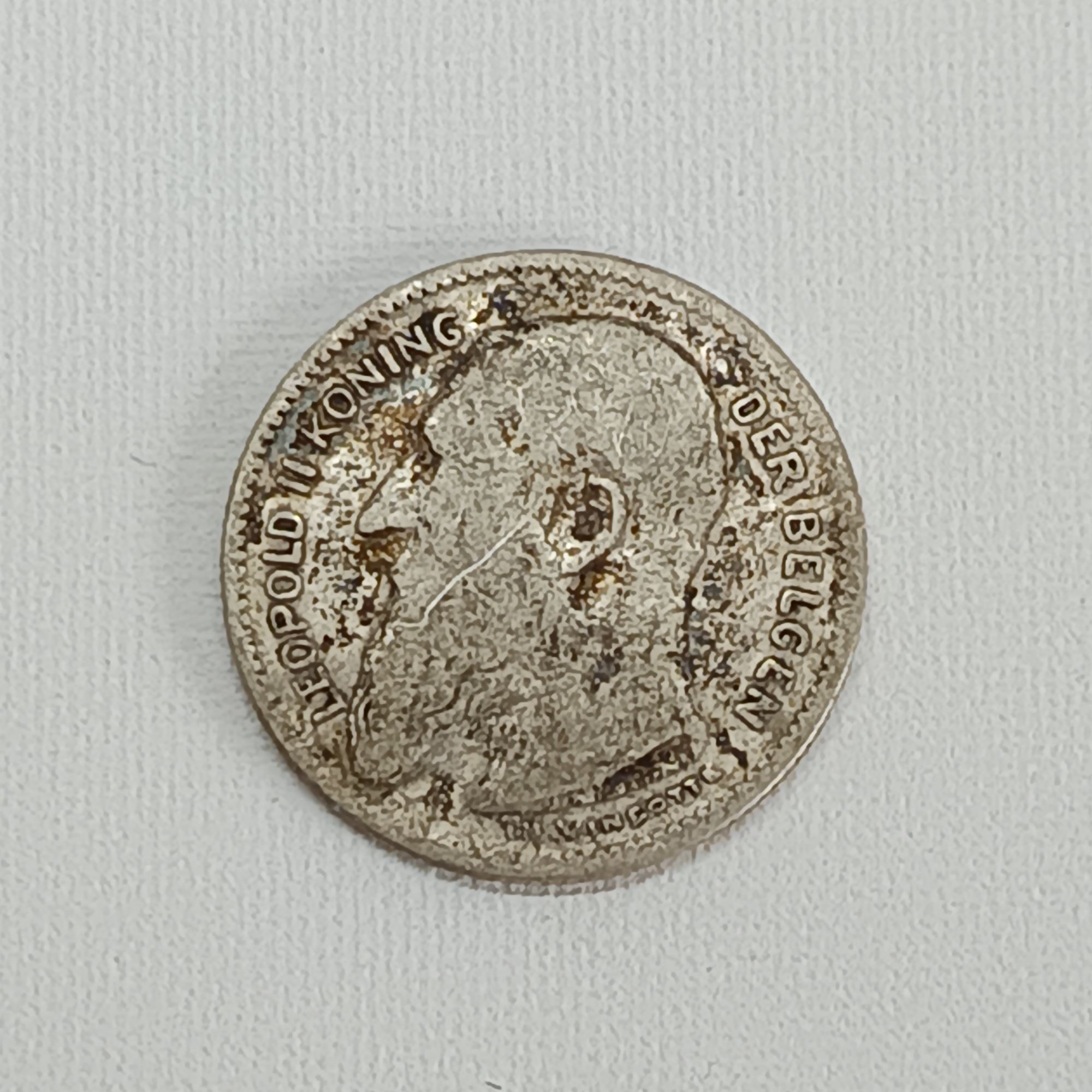 La pièce de 50 centimes de 1909 à l'effigie de Léopold II est une pièce belge en argent. Voici ses caractéristiques principales : * Monarque : Le Roi Léopold II de Belgique * Année d'émission : 1909 * Composition : Argent (.835 millièmes) * Poids : 2,5 grammes * Diamètre : 18 mm * Graveur : Thomas Vinçotte * Avers (côté face) : Un portrait de profil du roi Léopold II tourné vers la gauche, avec la légende "LEOPOLD II ROI DES BELGES" (en français) ou "LEOPOLD II KONING DER BELGEN" (en néerlandais/flamand). * Revers (côté pile) : La valeur nominale de la pièce "50 CENTIMES" et l'année "1909" entourées d'une couronne de branches de chêne et de lierre. Il existe deux versions principales de la pièce de 50 centimes de 1909 de Léopold II : l'une avec la légende en français et l'autre en néerlandais. La valeur de la pièce peut varier considérablement en fonction de son état de conservation, de sa rareté et de sa version linguistique.