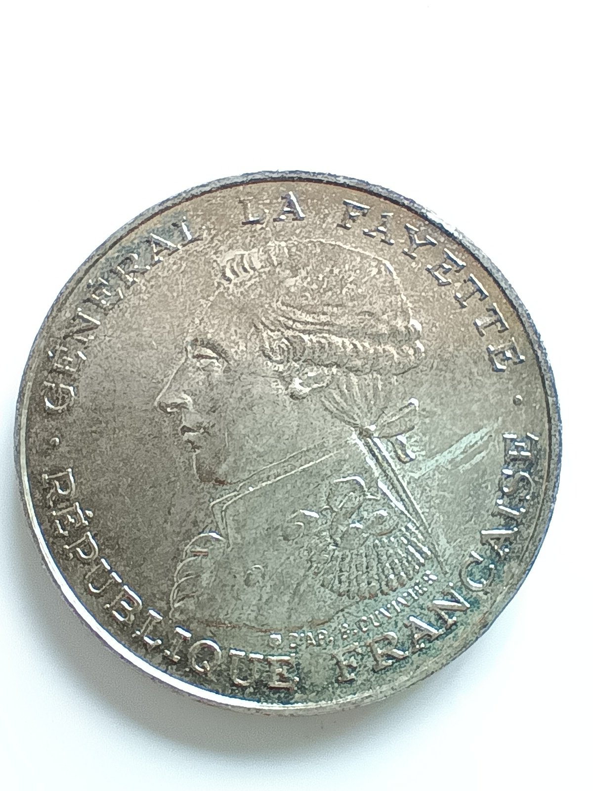 C'est une pièce de monnaie commémorative de 100 Francs Général La Fayette frappée en France en 1987, existant en argent, or, palladium et platine, sa valeur varie donc largement selon le métal et l'état.