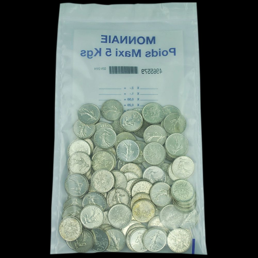 L'image montre : * Un sachet en plastique transparent contenant un grand nombre de pièces de monnaie. L'inscription sur le sachet, visible à travers le plastique et partiellement en miroir, mentionne ce qui semble être "MONNAIES" (MONNAIES) et possiblement une référence au poids ou au contenu. * Un tas de pièces de monnaie en métal gris ou argenté, qui semblent être des pièces françaises de 5 francs Semeuse (comme l'indique le titre du fichier "Lot-piece-de-monnaie-5-francs-semeuse"). Elles ont un aspect assez usé et sont empilées de manière aléatoire dans le sachet. En résumé, il s'agit d'un lot de nombreuses pièces de 5 francs Semeuse françaises dans un sachet en plastique.