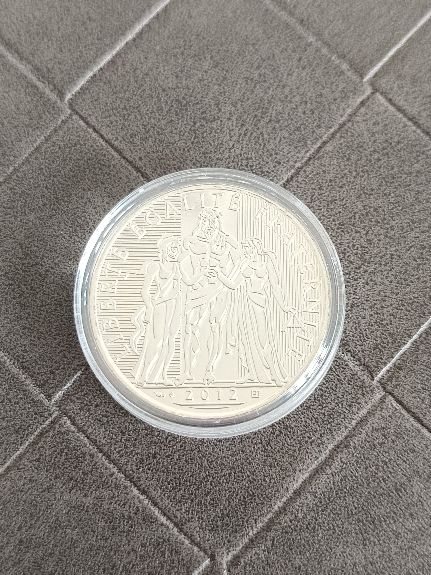 Pièce de 10 euros Hercule argent commémorative France 2012 représentant une réinterprétation stylisée d'Hercule avec sur le pourtour l’inscription Liberté Egalité Fraternité et millésime 2012.