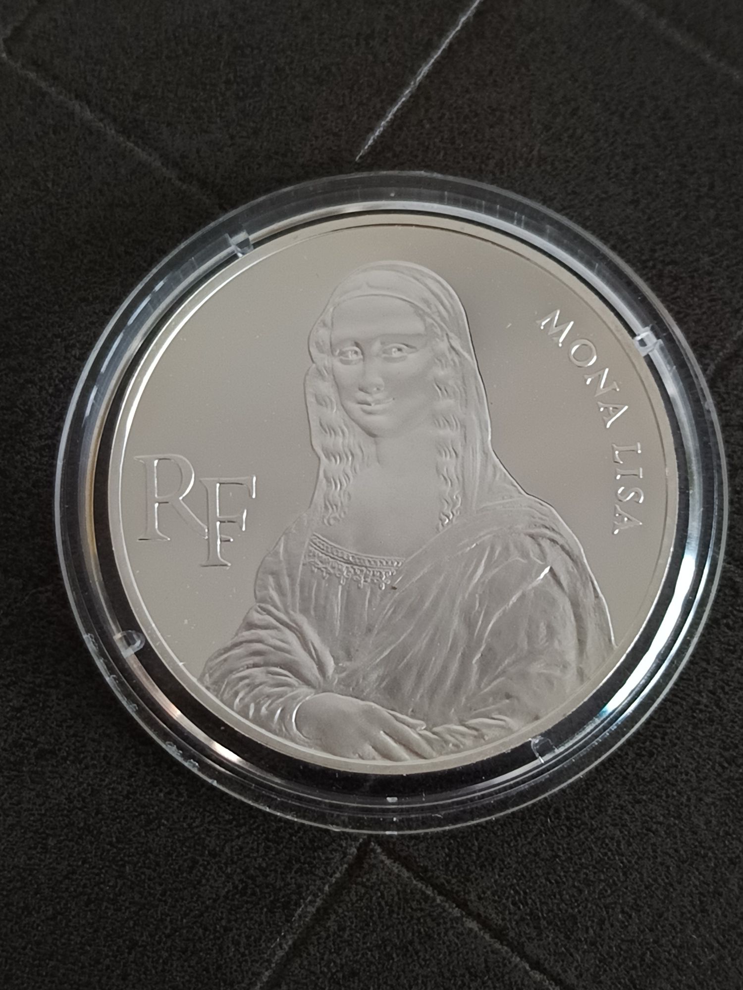 La pièce de 100 francs Mona Lisa de 1993 est une monnaie commémorative française en argent (900‰), émise pour le bicentenaire du Musée du Louvre. * Avers : Le portrait de la Joconde (Mona Lisa) de Léonard de Vinci avec la légende circulaire "MONA LISA RF". * Revers : Une vue du Musée du Louvre avec ses deux pyramides, la valeur faciale (100F) et la légende "BICENTENAIRE DU MUSÉE DU LOUVRE 1993".